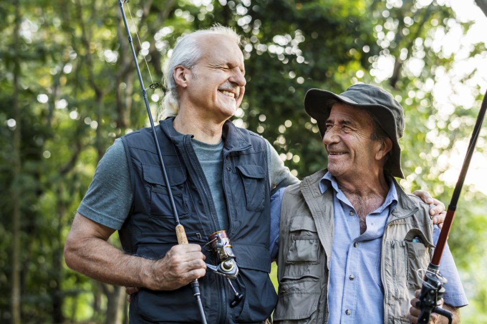 Senior friends fishing by the lake